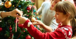 Siblings decorating the family christmas tree