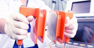 a doctor using a defibrillator