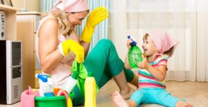 A mom cleaning up a mess made by her daughter.