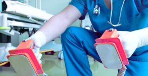 a doctor about to use a defibrillator