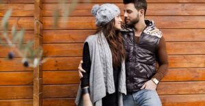 Couple posing for Thanksgiving pictures in fashionable attire