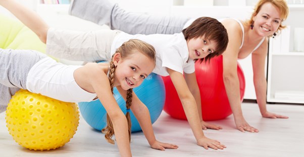 A woman working out in her home gym with her kids