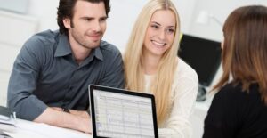 A financial advisor discusses details with a young couple
