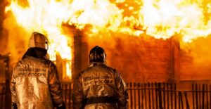 Firefighters watch a building burn
