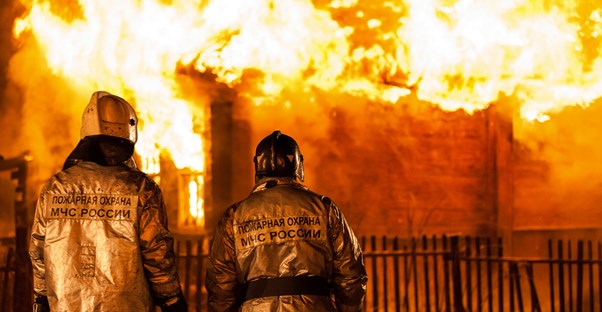Firefighters watch a building burn