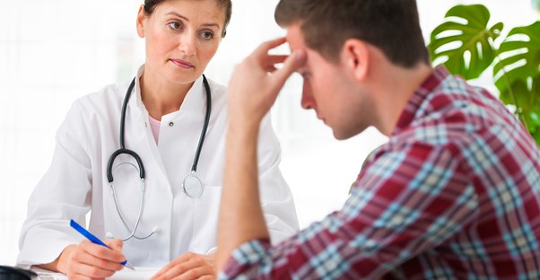 Man discussing how diet can improve his migraine pain with a doctor.