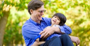 a parent hugging a boy with cerebral palsy