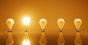 An energy efficient bulb lit next to regular bulbs.