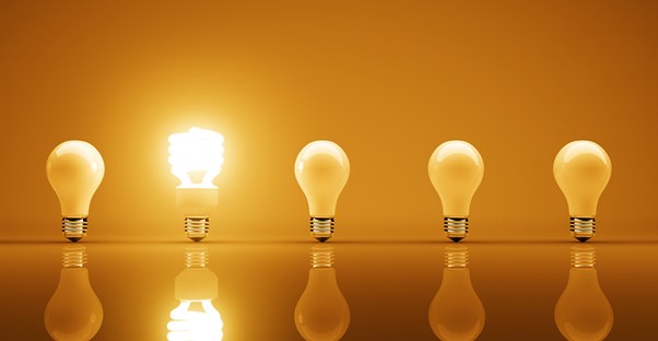 An energy efficient bulb lit next to regular bulbs.