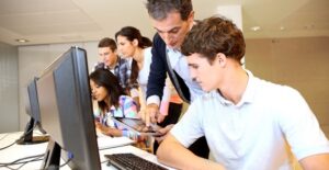 Teenagers work on computers and tablets