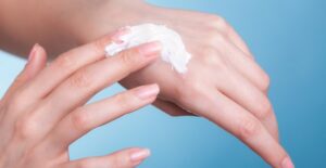 Woman moisturizing her dry winter skin.