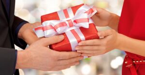 Woman giving a Valentine's Day gift to her boyfriend.