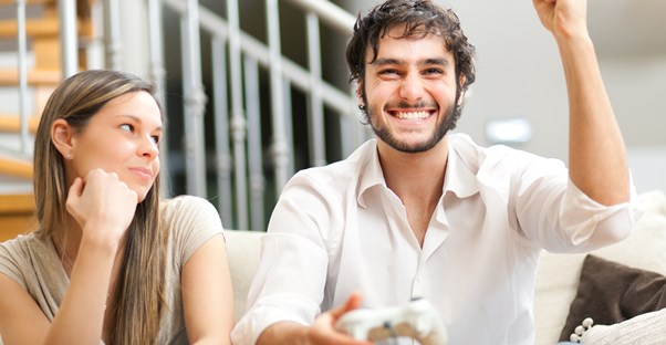 Girl rolls her eyes while her boyfriend plays video games