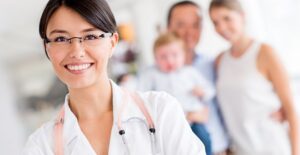 A pediatrician poses for a picture with a family