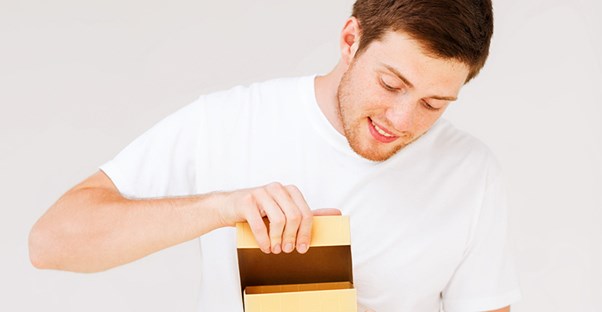 A guy opening a subscription box.