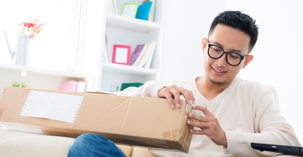 Guy opening a subscription box order.