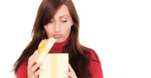 A woman frowning as she opens her subscription box order.