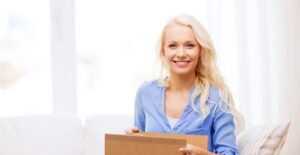 Woman smiling as she opens her subscription box order.