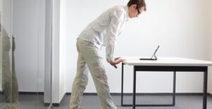 A man stands while working on his computer at the office