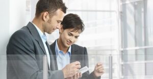 Coworkers look at productivity apps on a smart phone