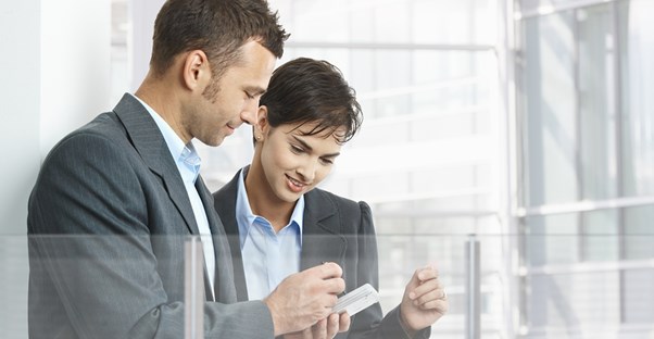 Coworkers look at productivity apps on a smart phone