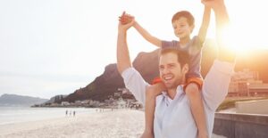 A gay man plays with his son on the beach.