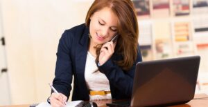 A secretary answering the phone and taking notes.