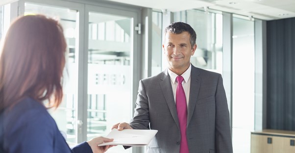The boss gives a receptionist paperwork