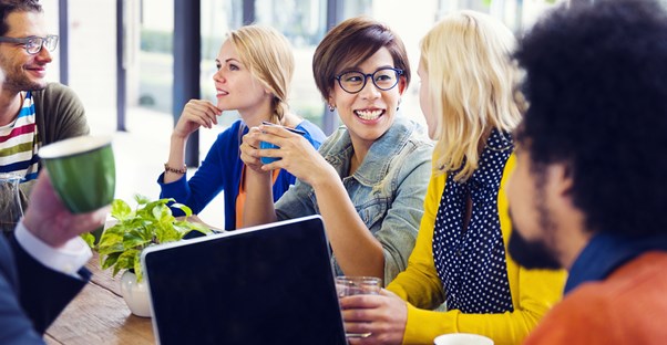 A group of coworkers talk over coffee