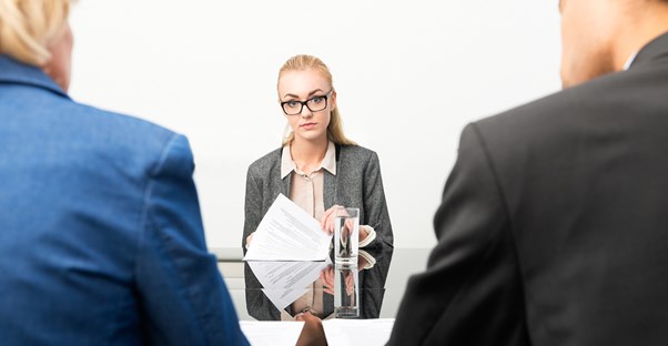 A young woman holds her resume during a job interview