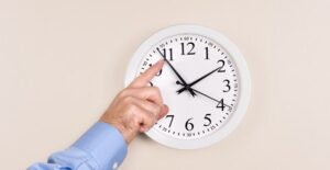 A man adjusting his clock for Daylight Saving Time.