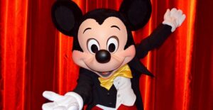 Mickey Mouse in front of a red curtain