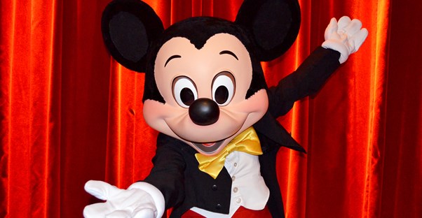 Mickey Mouse in front of a red curtain