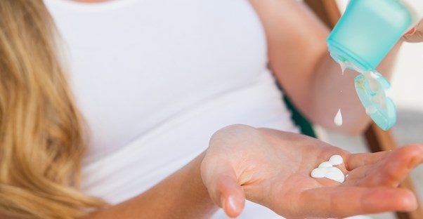 a woman applying sunblock