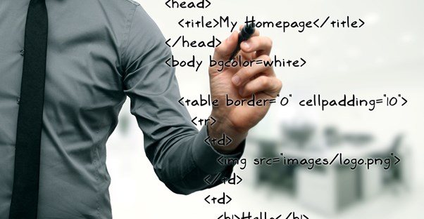 Computer scientist writing HTML code on a white board.