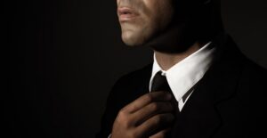 A man in a suit fixes his tie