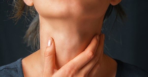 A woman medicates her sore throat