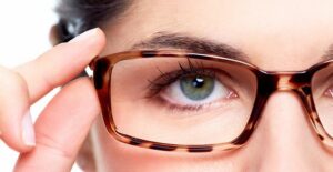 Woman trying on her glasses she bought with vision insurance