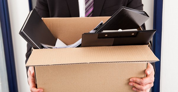 An employee cleans out his cubicle after getting fired