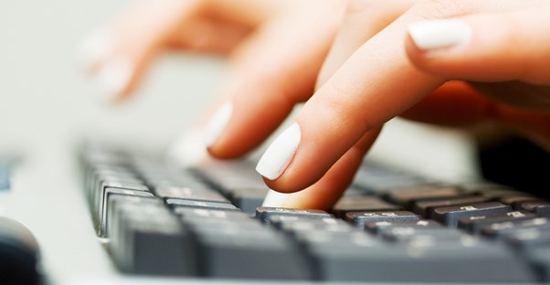 Perfectly manicured fingers type away on a keyboard