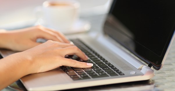 A writer types up a document on a laptop