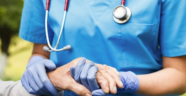A nurse takes the pulse of a patient