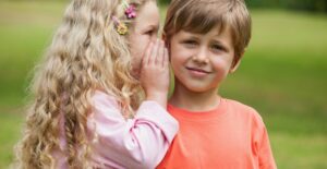 A little girl telling her brother a secret