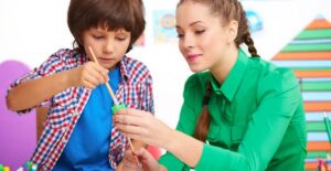 A teacher helps her student with an art project