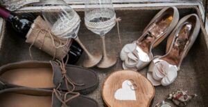 Shoes and wine glasses are laid out as decor for a wedding