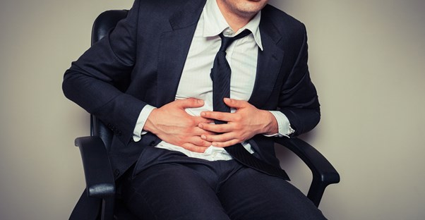 a man holds his stomach from indigestion