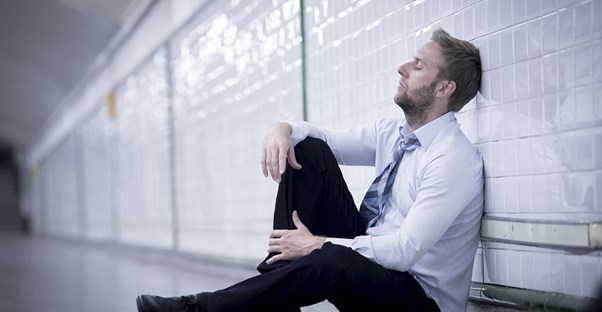 a man leans against a wall exasperated from his fibromyalgia pain