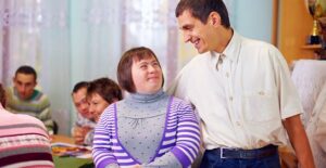 A teacher gives his student a side hug
