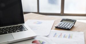 A computer and a calculator used to calculate investment returns