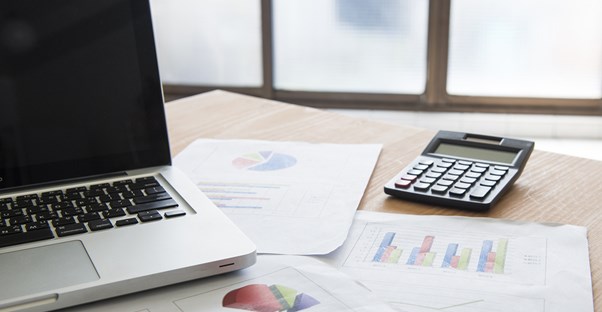 A computer and a calculator used to calculate investment returns